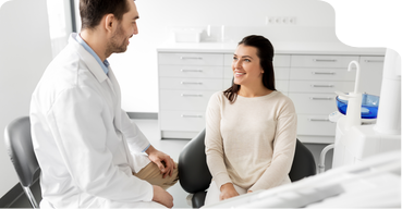 Dentist talking with a smiling patient in the treatment room