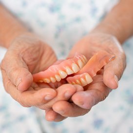 Hands holding a set of dentures